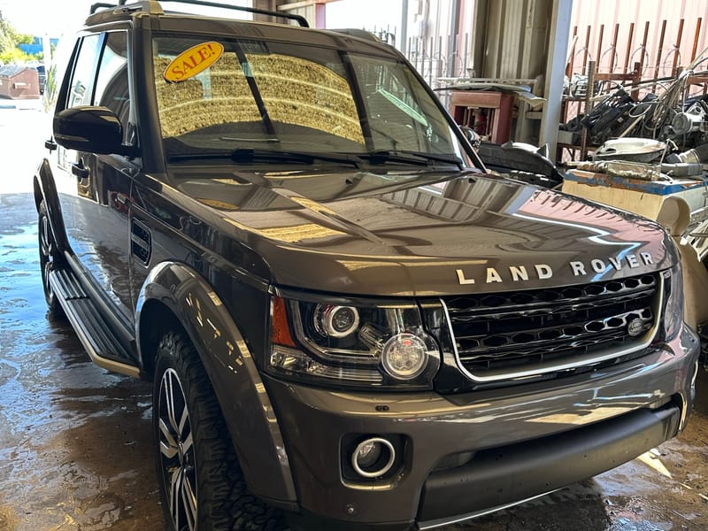 Dark grey 2016 Land Rover LR4 photographed at a front three-quarter angle inside the service bay