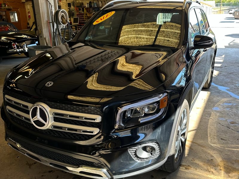 Black 2021 Mercedes-Benz GLB SUV photographed at a front three-quarter angle inside the service bay