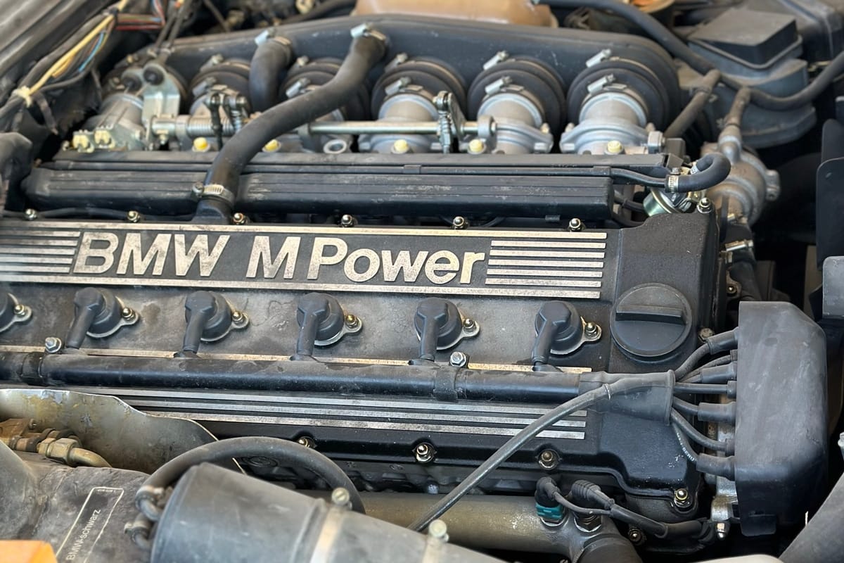 The BMW M Power engine cover and straight-six cylinder head of a serviced BMW engine bay